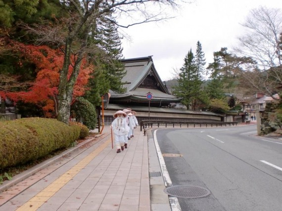 高野山内の道路脇に設置された「木製ガードレール」　（白装束の信者さんと調和したベストショット）