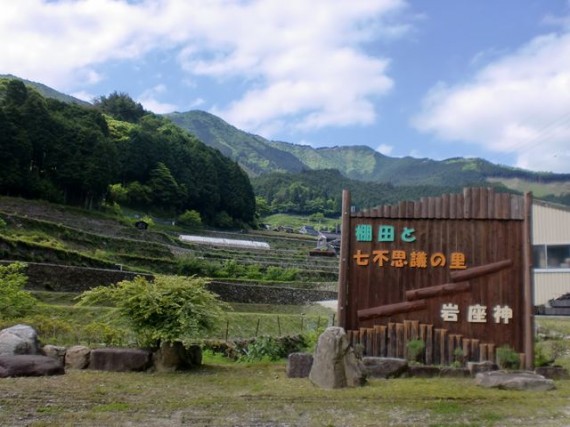 創業の地・棚田百選「岩座神（いさりがみ）」の入口に立つ　『木製看板』