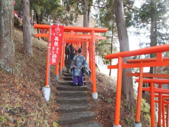 「稲荷鳥居」の間を歩く参列者たち